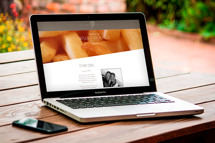 Laptop met de website van Frituur 't Krokantje, met een foto van verse frieten